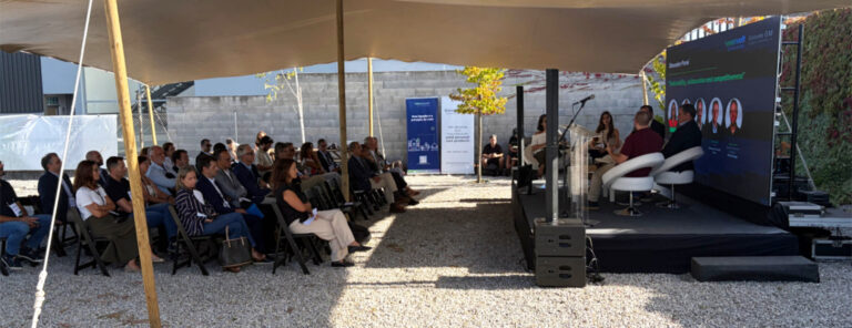 Mesa-redonda sobre Comunidade de Energia em frente aos painéis solares do Groupe GM, com o público a assistir
