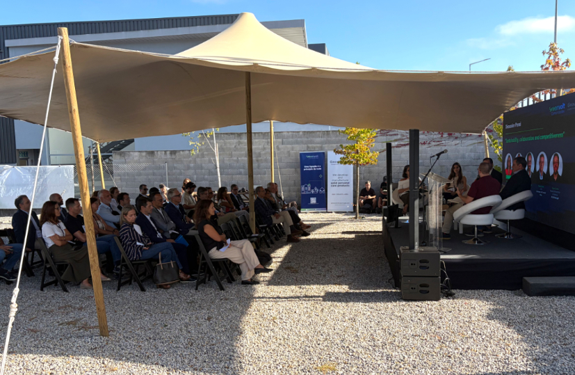 Mesa-redonda sobre Comunidade de Energia em frente aos painéis solares do Groupe GM, com o público a assistir